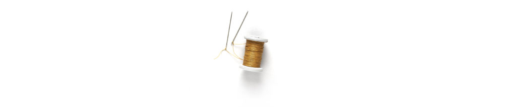 A spool of thread with needles